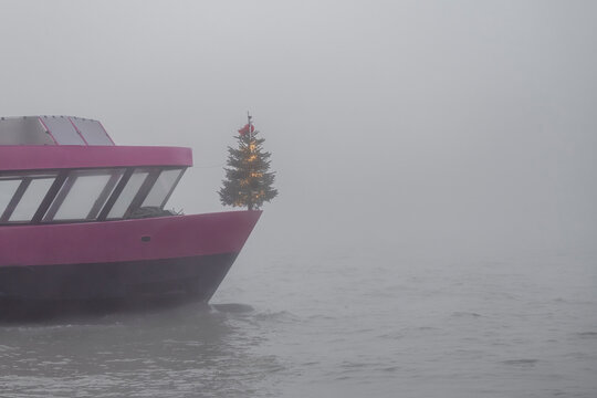 Christmas tree standing on bow of ferry shrouded in thick fog