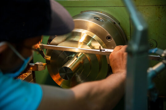 The machine operator measure diameter of brass material parts by Vernier caliper.