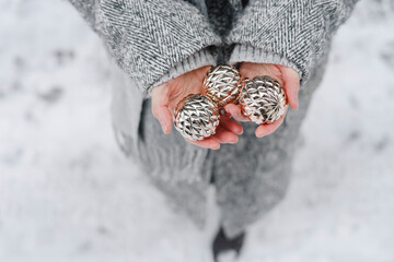 Woman holding silver sphere balls at winter