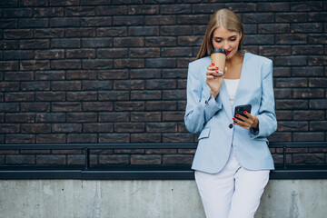Young business woman drinking coffee and talking on the phone