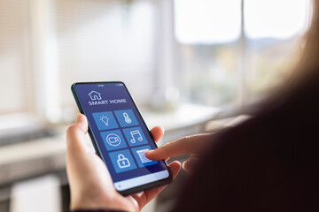 Woman touching device screen with smart home application