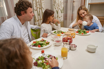 Cheerful female person giving tea to her son