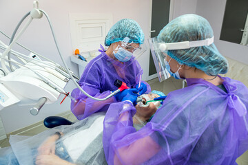 the patient lies on the operating chair where he is operated by a dentist and his assistants.