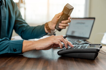Business hands using telephone in office. Businessman dialing VoIP phone in the office.