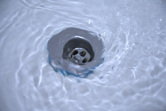 Water flowing down the hole in a kitchen sink.