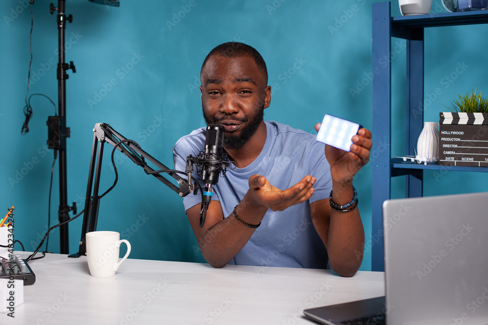 Poster portrait of vlogger presenting new model videography continous lighting on desk for vlog podcast usi