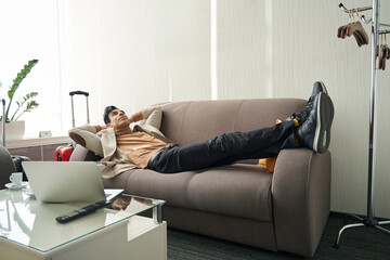 Man relaxing in hotel room on sofa