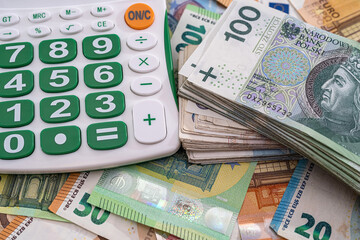 very large amounts of euro banknotes and zlotys and a calculator with a beautiful keyboard.