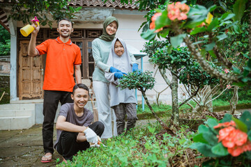 Happy family smiling while standing in the yard while gardening