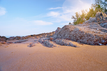Beautiful beach with golden sand, rocks and blue sky.