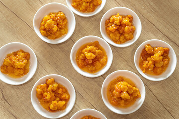 Juicy ripe cloudberry northern in a plate. Many plates on the table.