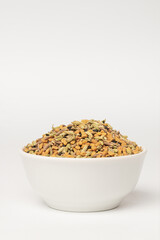 Panch phoron  or panchpuran  Indian and Bengal five spice seeds  blend for cooking  consisting of fenugreek, fennel, cumin, mustard seeds, onion seeds or black cumin in bowl on white background
