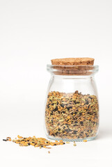 Panch phoron  or panchpuran  Indian and Bengal five spice seeds  blend for cooking  consisting of fenugreek, fennel, cumin, mustard seeds, onion seeds or black cumin in glass jar on white background