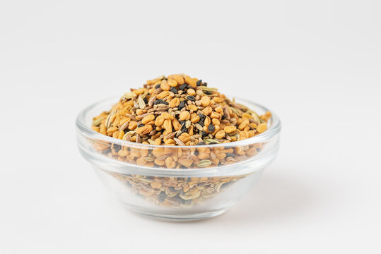 Panch phoron  or panchpuran  Indian and Bengal five spice seeds  blend for cooking  consisting of fenugreek, fennel, cumin, mustard seeds, onion seeds or black cumin in bowl on white background