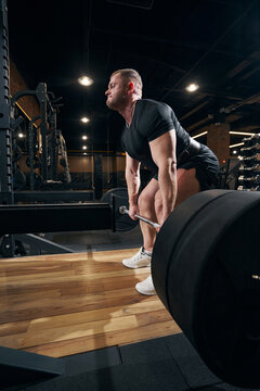 Focused lifter doing deadlift in fitness room