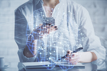 Double exposure of brain sketch hologram and woman holding and using a mobile device.