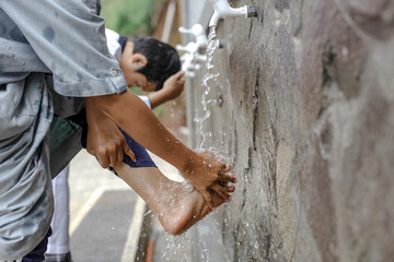 Close up An islamic boarding school students is doing ablution washing his feet