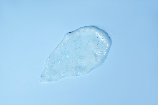 Cream scrub smear smudge stroke isolated on blue background. Cosmetic exfoliating scrub texture. Blue skincare mask sample cut out