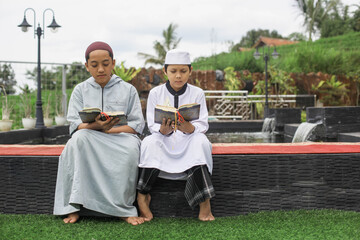 Islamic boarding school students memorize the Qur'an in the courtyard of the mosque
