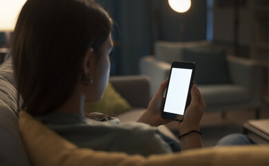 Woman sitting on the sofa and using her smartphone