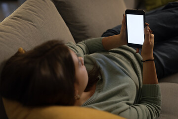 Girl relaxing on the couch and connecting with her smartphone