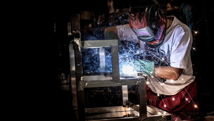 Fototapeta na wymiar Man welding in a workshop