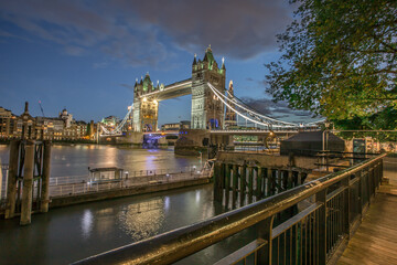 The iconic Tower Bridge in London, view to the illuminated Tower Bridge and skyline of London, UK, just after sunset.