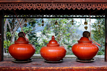 Three pieces of classic style orange pottery water jar on table outdoor.