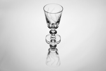 Bicchiere a calice in cristallo inciso si riflette su un fondo a specchio