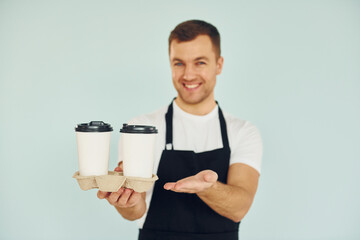 Man in uniform standing in the studio with drinks in hands