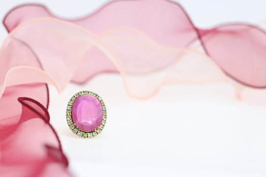 Red ruby rings with pink ribbon on white background. Jewelry set of gemstone for shop