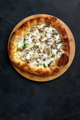 Delicious homemade pizza with mozzarella, mushrooms, beef and chicken. Dark background, selective focus.