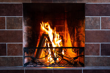Burning fireplace, close up.  Cozy atmosphere autumn or winter evening. Open fire with real flames...