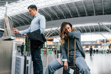 Woman is tired. Young couple is in the airport together