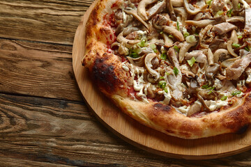 Delicious homemade pizza with mozzarella, mushrooms, beef and chicken. Wooden background, selective focus.