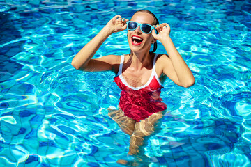 Happy vacation. Colorful portrait of young smiling woman at swimming pool. - Powered by Adobe