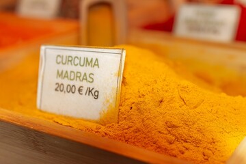 Curcuma powder in wooden container, spice of South Indian origin, selective approach.