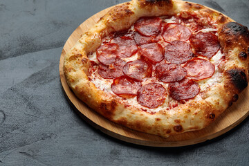 Tasty pepperoni pizza on black concrete background. Top view of hot pepperoni pizza. With copy space for text.