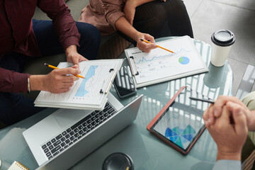 Hands of business colleagues meeting to discuss various charts with important data