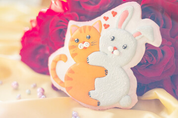 background banner greeting card for valentine's day with bouquet of red roses and gingerbread heart cookies with cat and rabbit hugs on silk fabric background