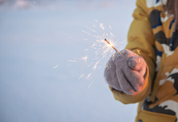 Close-up of a Bengali candle in hand in a hand in a twivel in winter.