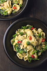 Italian pasta Orecchiette with turnip leaves (cima di rapa) and tops with garlic, hot pepper,...