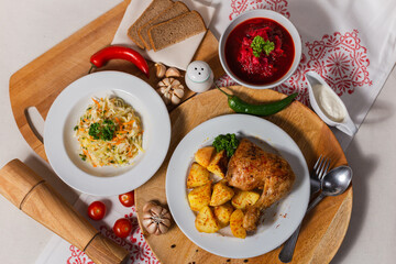 dishes of Russian cuisine on the table borscht, chicken, potatoes, salad