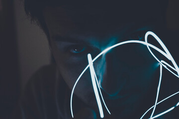 Mysterious and disturbed portrait of a young man in darkness