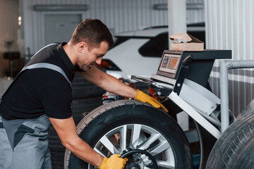 Fototapeta na wymiar Work in progress. Man in uniform is in the auto service