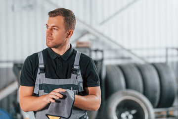 In black shirt. Man in uniform is working in the auto service