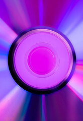 Vintage CD or DVD disc in vibrant bold gradient holographic neon colors. Pink, purple ad blue colors reflection. Minimal abstract wallpaper background design sample. Copy space.