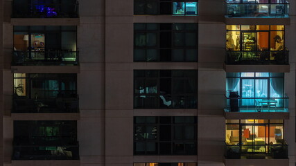 Windows of apartment building at night timelapse, the light from illuminated rooms of houses