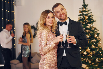 Beautiful couple. Group of people have a new year party indoors together