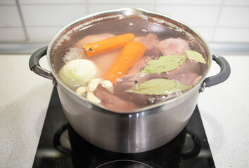 cooking at home, vegetables, meat, bay leaf are boiled in a pot at home. Homemade, meat broth, natural collagen